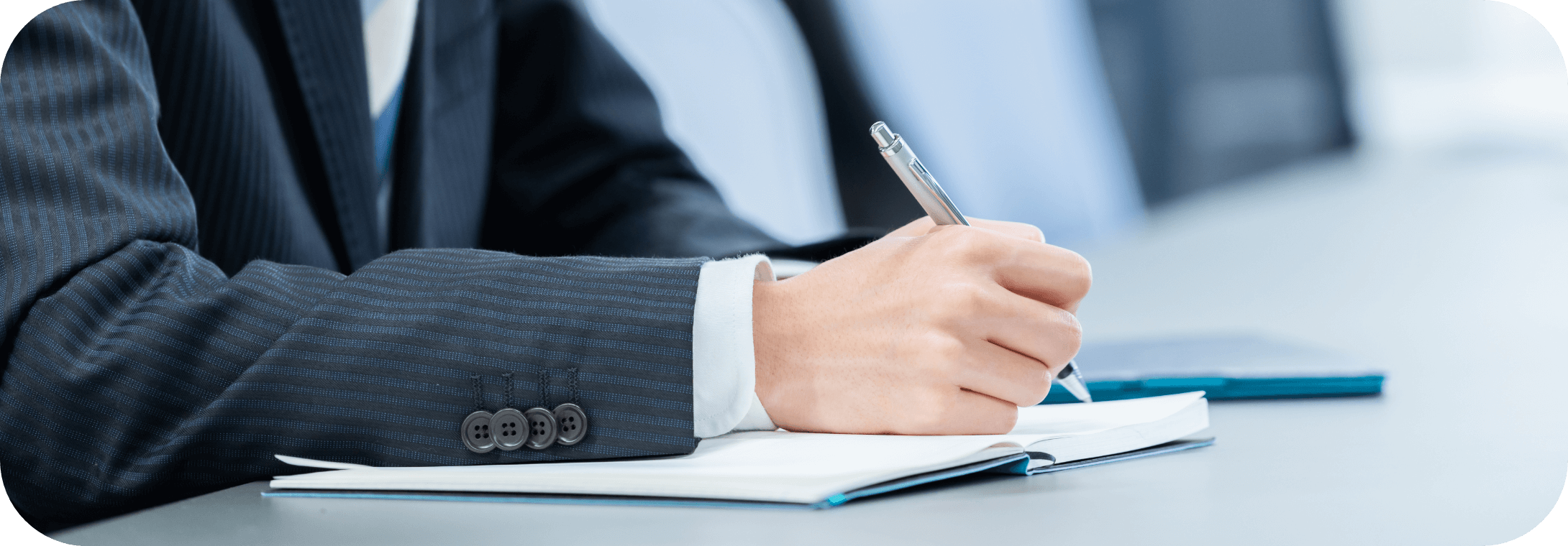 スーツ姿の男性がノートに書き込みをしている様子