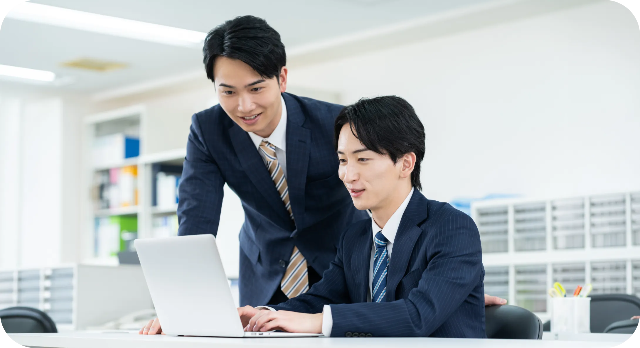 明るい室内でデスクワークに集中するスーツ姿の男性社員